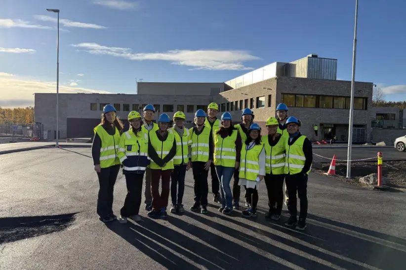 En gruppe mennesker i gule vester som står på en parkeringsplass