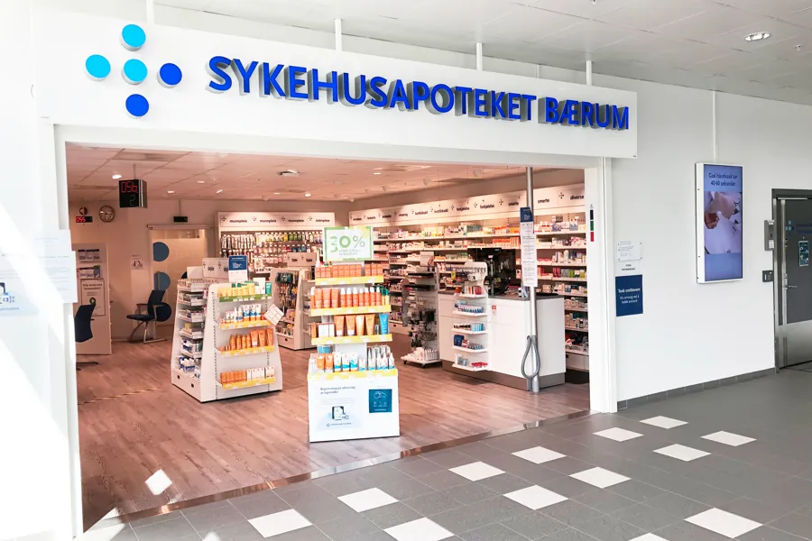 Man ser inn i et apotek med butikkhyllerhyller med fulle av varer. foto.